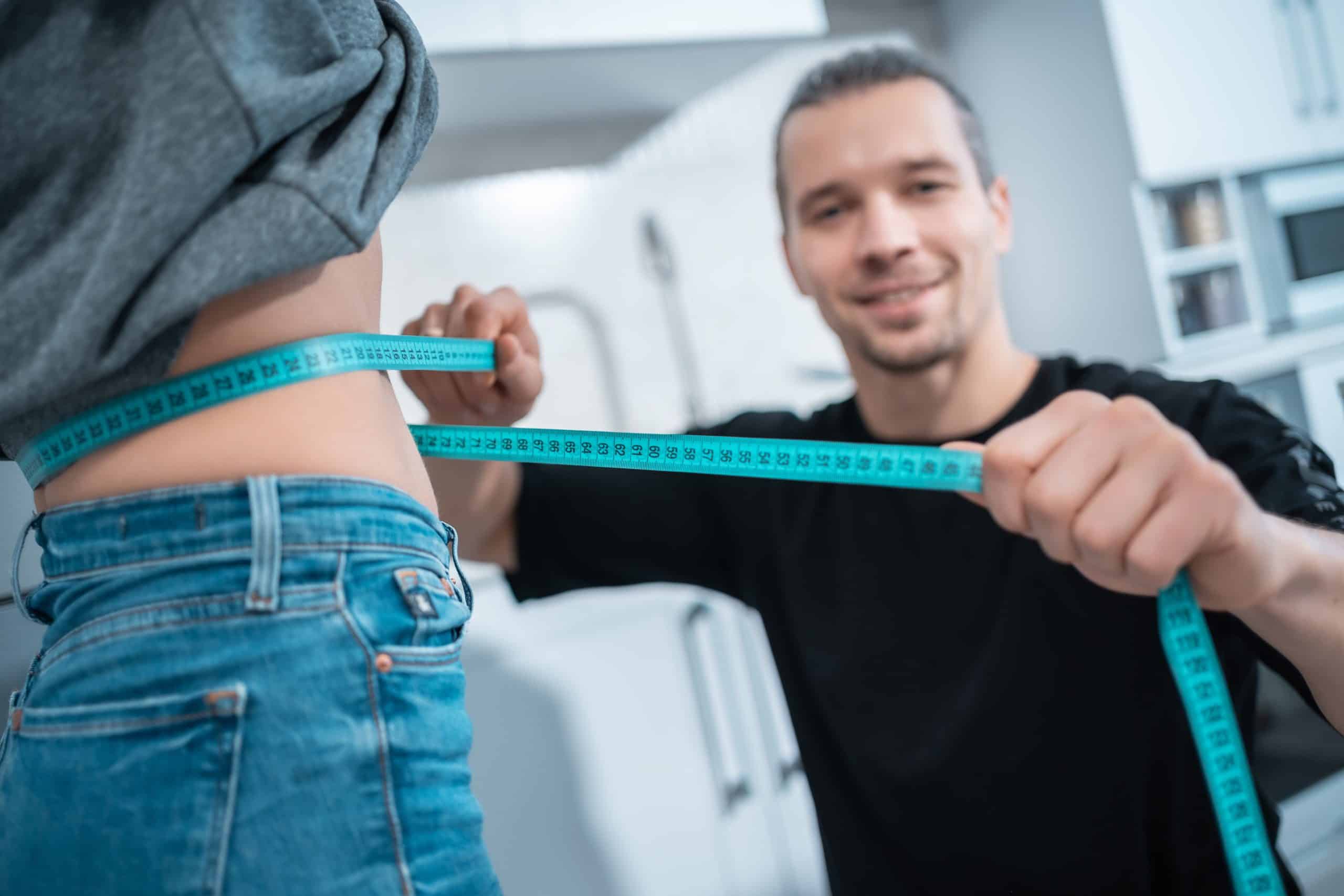 trener pokazujący brzuch bez tłuszczu po sesjach ćwiczeń